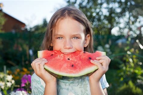 Premium Photo Little Girl Eating Watermelon In Nature