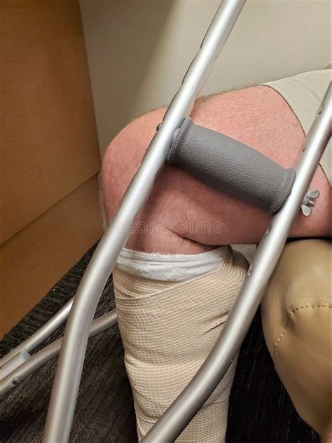 Bent Kneed Above Broken Leg In Cast With Crutch Over Office Carpet