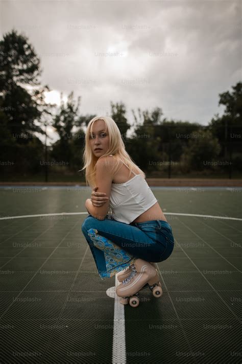 A Woman Sitting On Top Of A Skateboard On A Court Photo Skating Image