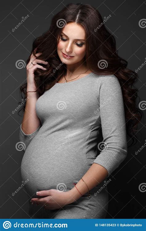 Beautiful Pregnant Woman In A Gray Dress With A Classic