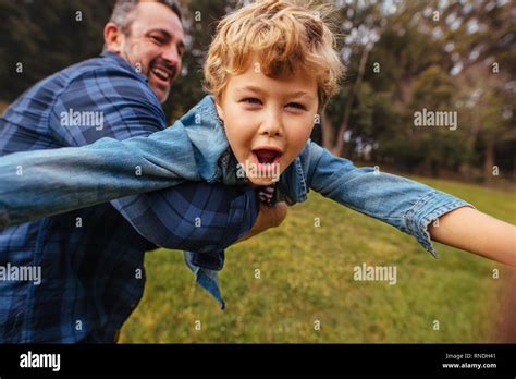 Son With His Father Having Fun In Park Happy Boy Playing With Dad