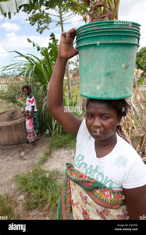 A Woman Stands At A Rural Well In A Village Outside Dar Es Salaam