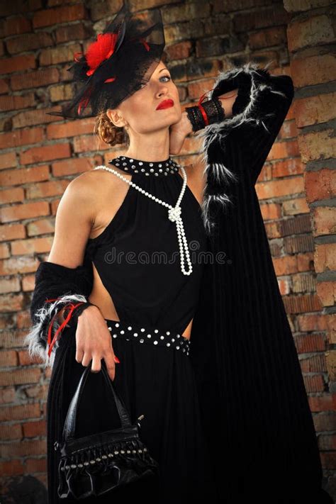 Элегантная женщина в черных платье и шляпе с вуалью Стоковое Изображение изображение