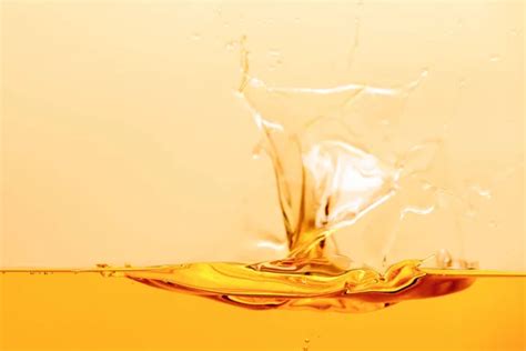 Yellow Bright Liquid Splash With Drops Isolated On Yellow