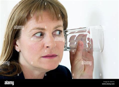 Woman Listening To Conversation Through Wall With An Ear To A Glass