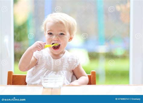 Cute Baby Girl Eating Yogurt From Spoon Stock Photo Image Of Garden