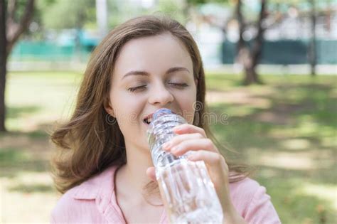 Young Caucasian Woman Girl Drinking Water From A Plastic Bottle In