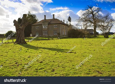 Large Traditional British Farmhouse With Dead Tree In The Countryside