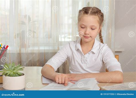 Schoolgirl Studying At Home Young Girl Reading Book At The Table