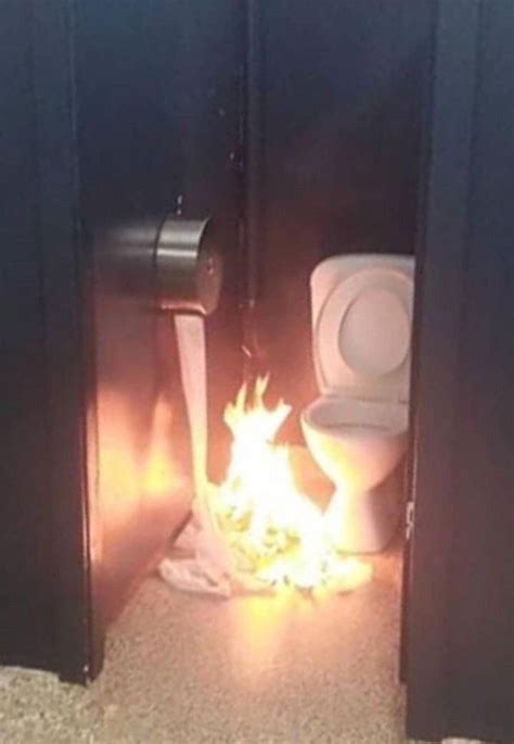 The Toilet Is On Fire In The Bathroom Stall Next To The Trash Can And