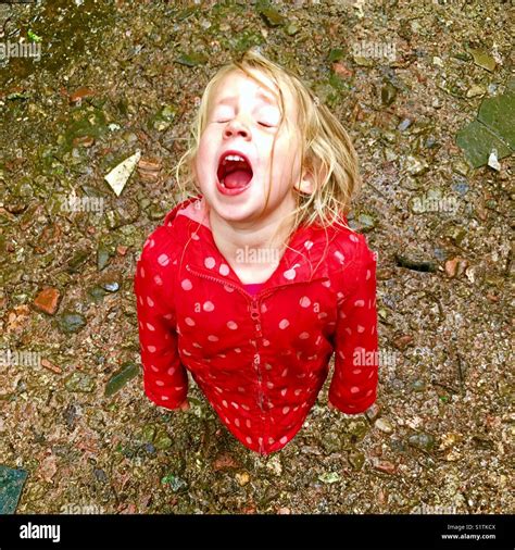 Young Girl Trying To Catch Raindrops In Her Wide Open Mouth Loving