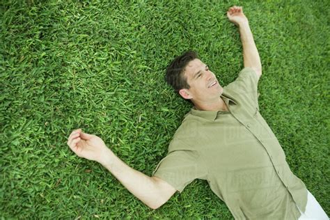 Man Lying On Grass Smiling Stock Photo Dissolve