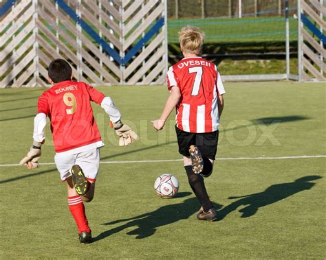 Two Young Football Players Running After A Ball Stock Image Colourbox