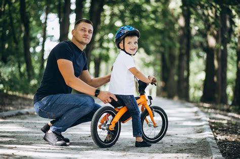 Padre Enseñando A Su Hijo A Andar En Bicicleta Al Aire Libre Foto Premium