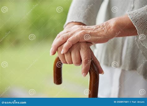 Closeup Of A Senior Disabled Womans Hands Holding A Cane Outside In