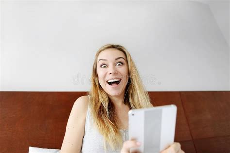 Young Woman Happy Shocked With Tablet Looking At Camera At White Bed