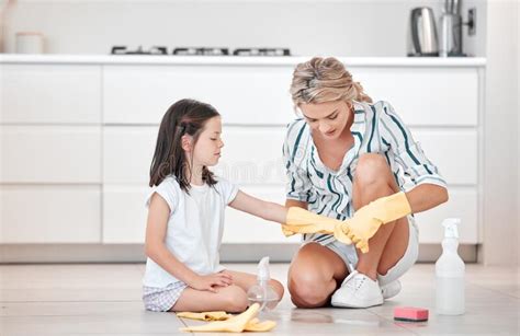 Mother And Daughter Wearing Gloves Cleaning The Floor At Home Cute