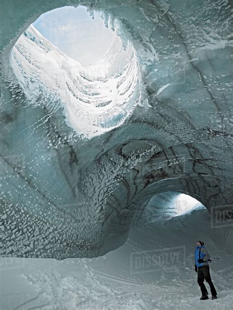 Man Exploring Ice Cave In Iceland Stock Photo Dissolve
