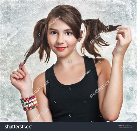 A Beautiful Teen Girl In Black Top Holding Her Pigtails Portrait