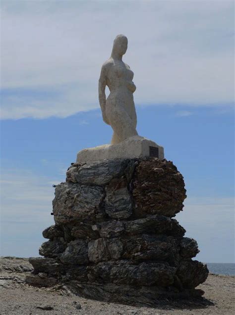 a statue is sitting on top of a rock