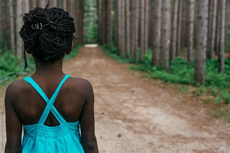 african american girl in blue dress on a road in the forest by stocksy contributor gabi