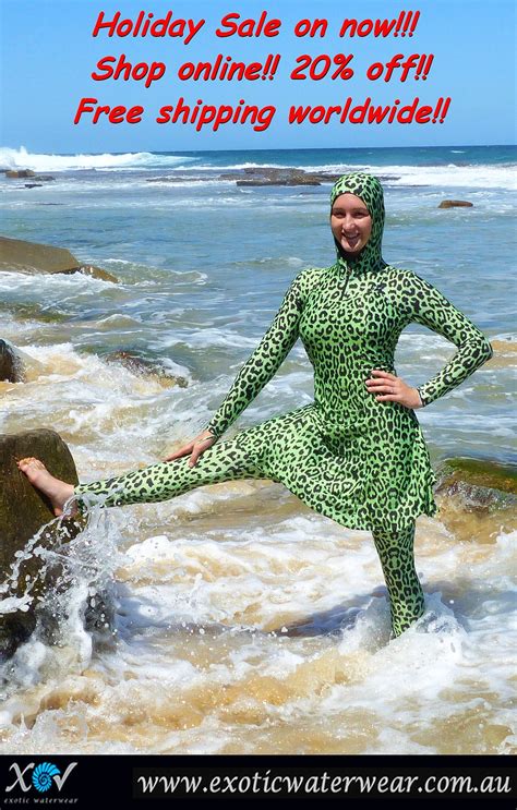 a woman standing in the ocean wearing a green leopard print dress