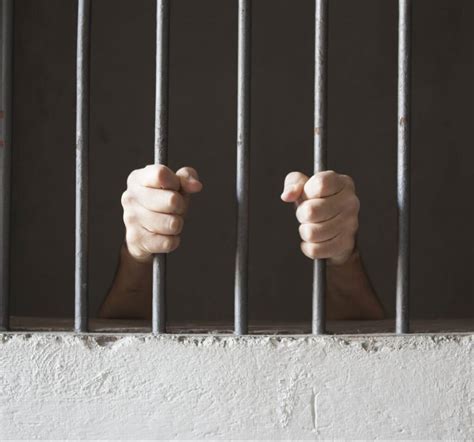 Hands Through Prison Bars