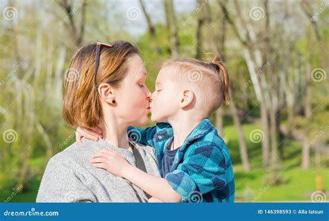 Mom Kisses Her Boy In The Park In Spring Stock Image Image Of Kisses