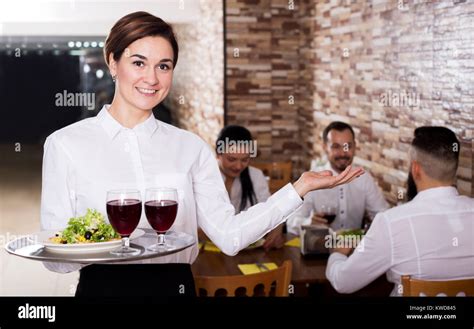 Smiling female waiter welcoming guests to country restaurant Stock Photo: 170551477 - Alamy