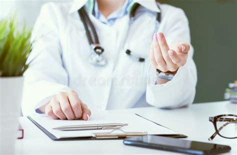 Female Doctor Explaining Patient Symptoms Or Asking A Question As They