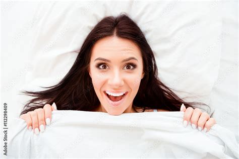 Top View Portrait Of Pleasantly Surprised Woman After Sleep Stock Photo
