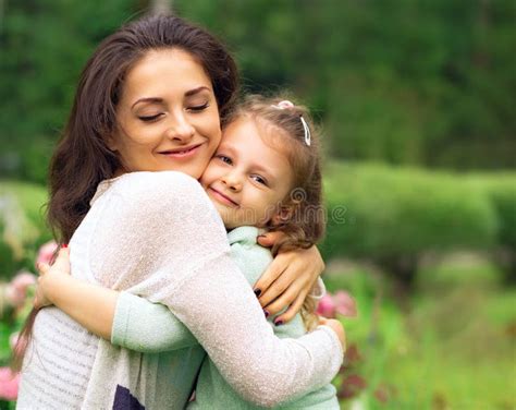 Bella Madre Y Linda Hija Pequeña Besándose En El Fondo Verde Del Verano