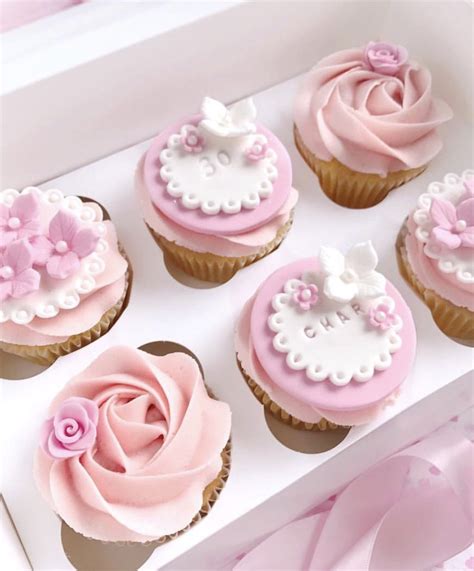 Cupcakes Decorated With Pink And White Frosting In A Box