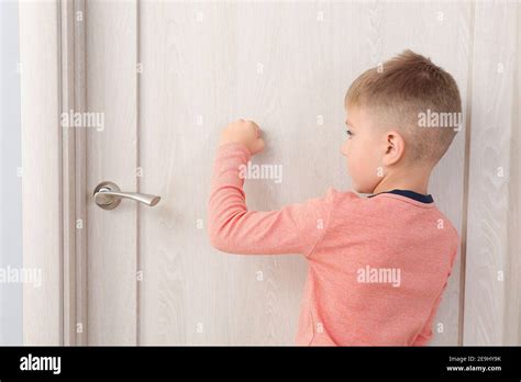 Cute Little Boy Knocking At The Door Stock Photo Alamy