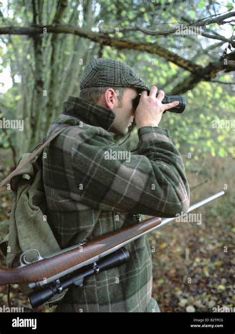 Deer Stalker With Binoculars And Rifle Stock Photo Alamy