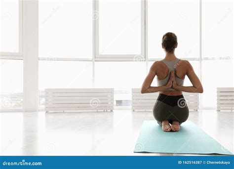 Young Woman Practicing Thunderbolt Asana With Reverse Prayer Arms In