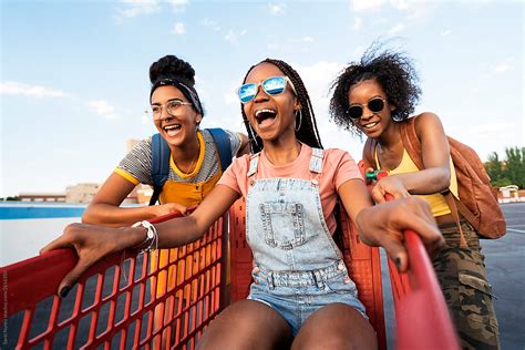 Smiling African Girls In Sunglasses Having Fun In Trolley Superm Del Colaborador De Stocksy