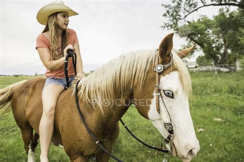 Young Woman Riding Bareback On Horse In Ranch Field Bridger Montana