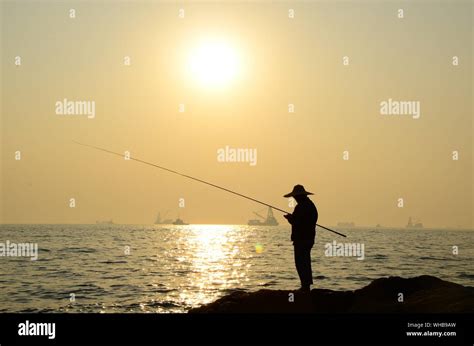 Silhouette Man Fishing In Sea Against Sunset Sky Stock Photo Alamy