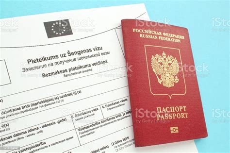 Formulario De Solicitud De Visado Schengen En Ruso Y Letón Y Pasaporte Sobre Fondo Azul Foto De