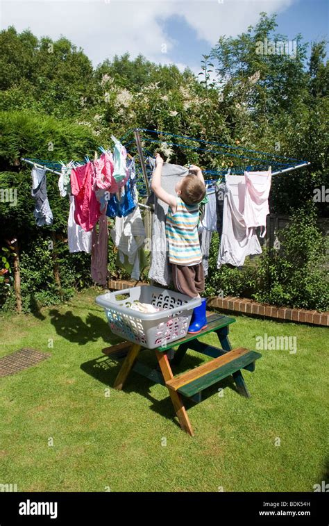 Young Boy Stretches To Hangiout The Washing Chores Clean Clothesline
