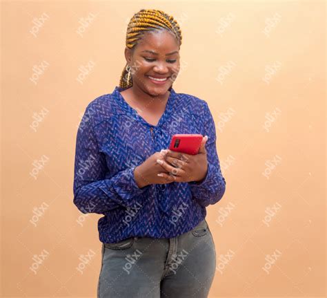 jeune femme africaine souriante manipulant son smartphone sur un fond beige photo 4506