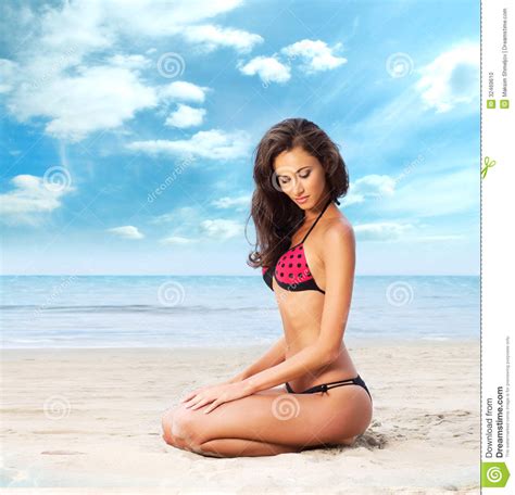 eine junge brunettefrau in einem roten badeanzug auf dem strand stockfoto bild von gesundheit