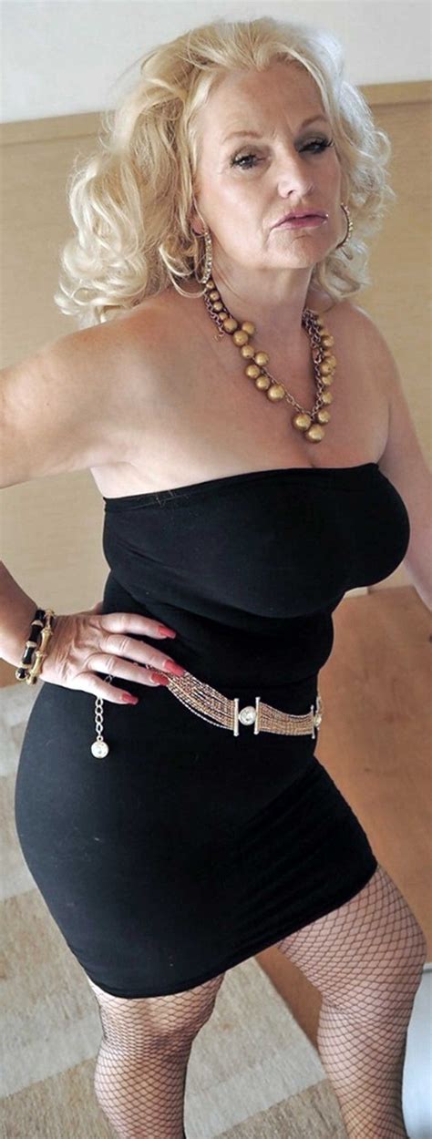 a woman in a black dress is posing for the camera with her hands on her hips