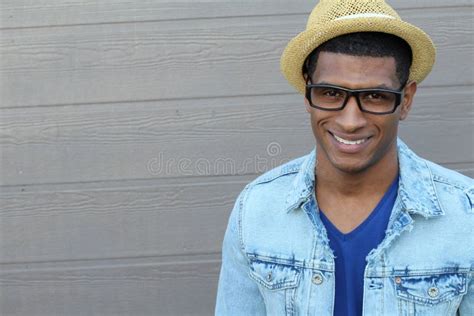 Close Up Smiling Young Black Man Wearing Eyeglasses Looking At The Camera Against Gray Wall