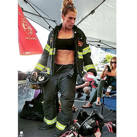A Woman In Firefighter Gear Is Standing Under A Tent