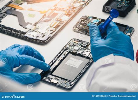 The Asian Technician Repairing The Smartphone S Motherboard In The Lab