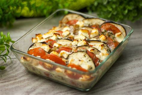 A Casserole Dish With Tomatoes Cheese And Other Toppings On A Table
