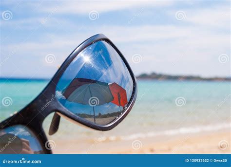 Sunglasses On The Beach Near The Sea Against The Sea Wave Stock Photo