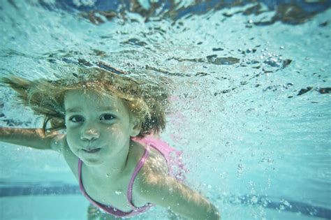 porträt eines mädchens das unter wasser im pool schwimmt lizenzfreies stockfoto